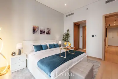 a bedroom with a large white bed and a table at RP Heights - Luxe 2BR with Burj Khalifa View - Zed Living in Dubai