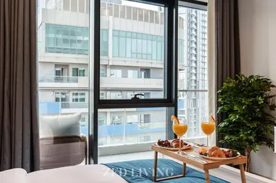 a room with a large window and a table with food on it at RP Heights - Luxe 2BR with Burj Khalifa View - Zed Living in Dubai