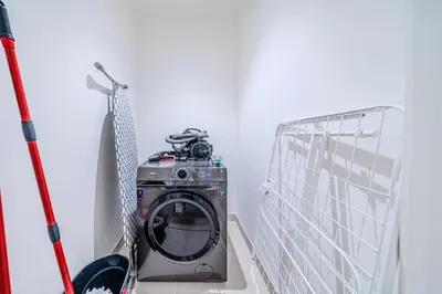 a washing machine in a room with a mirror at Elegant 1 Bedroom in Orchid at Creek Beach in Dubai