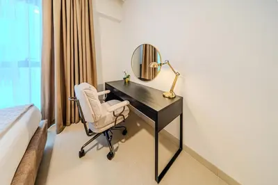 a bedroom with a desk with a mirror and a chair at Elegant 1 Bedroom in Orchid at Creek Beach in Dubai