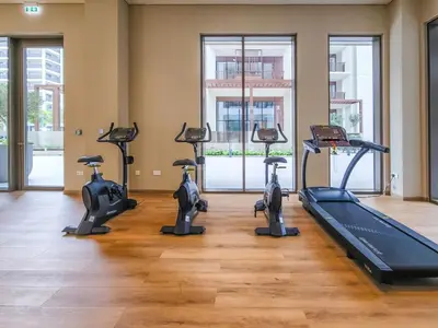a gym with several treadmills and a treadmill at Elegant 1 Bedroom in Orchid at Creek Beach in Dubai