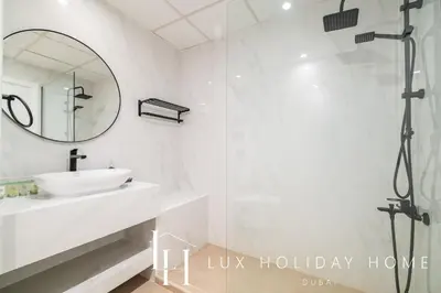 a white bathroom with a sink and a mirror at LUX The Dubai Eye View JBR Studio in Dubai