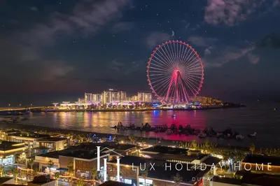 a ferris wheel is lit up at night at LUX The Dubai Eye View JBR Studio in Dubai