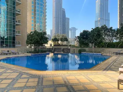 a large swimming pool in a city with tall buildings at Silkhaus Residences Towers 3BR Near Burj Khalifa in Dubai