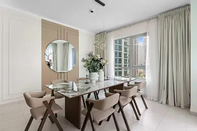 a dining room with a table and chairs and a mirror at Silkhaus Residences Towers 3BR Near Burj Khalifa in Dubai