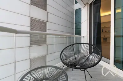 a bench sitting on a porch next to a building at Upgraded 2BR In La Riviera Marina - Close to Beach in Dubai