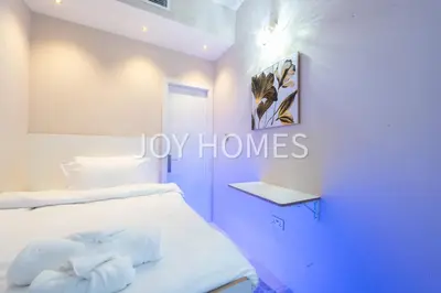 a bedroom with a white bed and a blue door at Amiralty Easy Stay in Dubai