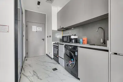 a kitchen with a washer and dryer in it at GuestReady - Modern studio with balcony in Dubai in Dubai