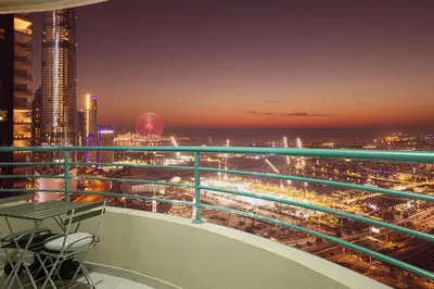 a balcony with a view of a city at night at Prime Location - 2BR with Spectacular Sea View in Dubai