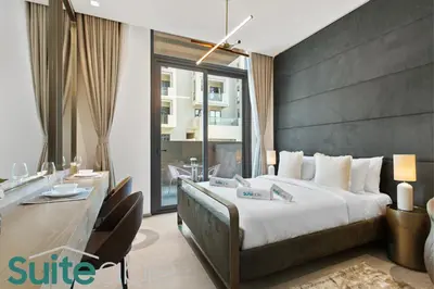 a hotel room with a large bed and a desk at Studio in The Autograph JVC w amazing facilities in Dubai