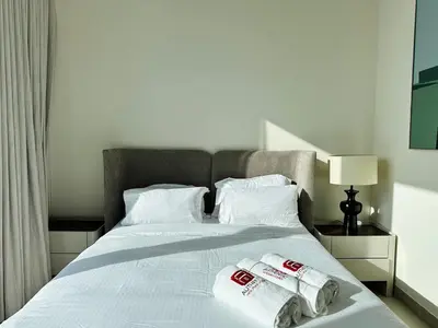 a bed with two towels on top of it at Your Home away from Home in Dubai