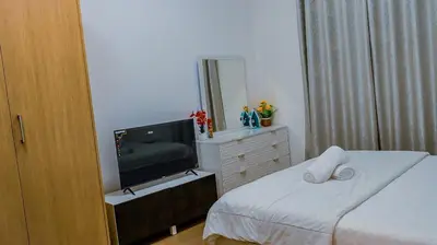 a bedroom with a bed and a television on a dresser at Luxurious holiday homes in Dubai