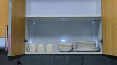 a cabinet filled with white bowls and plates at Luxurious holiday homes in Dubai