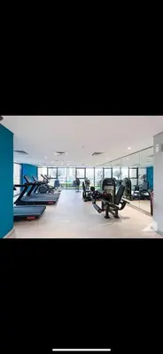 a gym with several treadmills and machines in it at Azizi riviera in Dubai