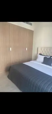 a bedroom with a large bed with a blue blanket at Azizi riviera in Dubai