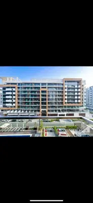 a large building with many windows in a parking lot at Azizi riviera in Dubai