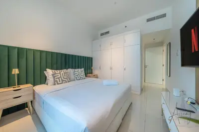 a bedroom with a large white bed and a green wall at Stunning Views Spacious 3BR Dubai Marina in Dubai
