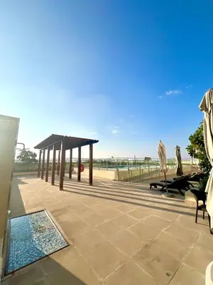 a patio with a pool and a pavilion at Vibrant studio - 15m to marina in Dubai