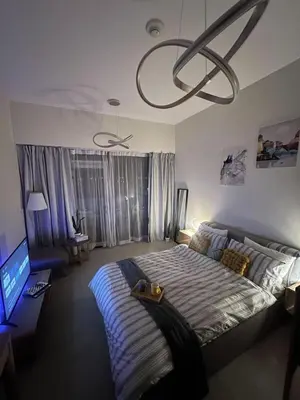 a bedroom with a large bed and a television at Vibrant studio - 15m to marina in Dubai