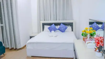 a hotel room with a bed and a table with flowers at 1BHK Homes For Holidays in Dubai