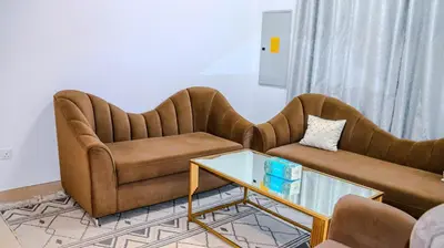 a living room with two couches and a table at 1BHK Homes For Holidays in Dubai