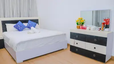 a bedroom with a white bed and a mirror at 1BHK Homes For Holidays in Dubai