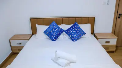 a bed with two blue pillows and two towels at Luxurious Studio Apartment in Dubai