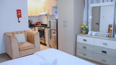 a kitchen with a couch and a chair in a room at Luxurious Studio Apartment in Dubai
