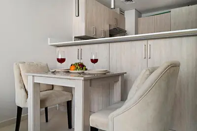 a kitchen with a table with two glasses of wine at 1BR Apartment on The Palm Walk to Beach Mall Pool Restaurants in Dubai