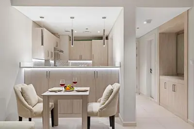 a kitchen with a table with two glasses of wine at 1BR Apartment on The Palm Walk to Beach Mall Pool Restaurants in Dubai