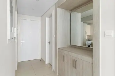 a white kitchen with a counter and a mirror at 1BR Apartment on The Palm Walk to Beach Mall Pool Restaurants in Dubai