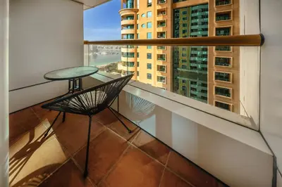 a balcony with a table and a view of a city at Cozy 1 Bedroom in Elite Residence in Dubai