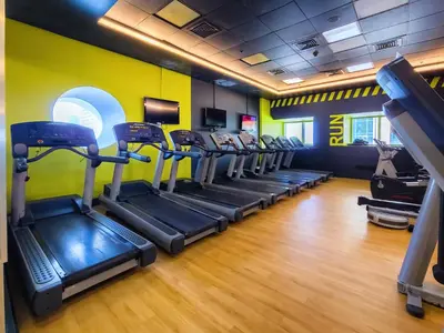 a gym with treadmills and elliptical machines at Cozy 1 Bedroom in Elite Residence in Dubai