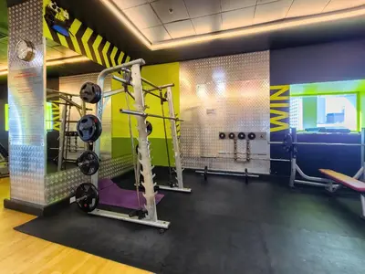 a gym with several tread machines in a room at Cozy 1 Bedroom in Elite Residence in Dubai