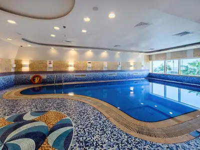 a pool in a hotel room with a swimming pool at Cozy 1 Bedroom in Elite Residence in Dubai