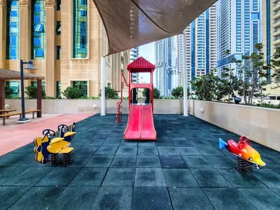 a playground in the middle of a city with buildings at Cozy 1 Bedroom in Elite Residence in Dubai