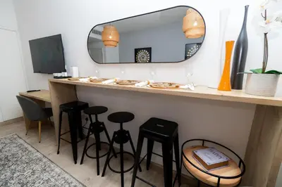 a bathroom with a counter with stools and a mirror at Boulevard Central Towers Downtown Dubai - By Home Of Choice in Dubai
