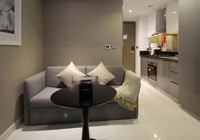 a living room with a couch and a table at Luxury Studio Apartment Canal View Near Dubai Mall in Dubai