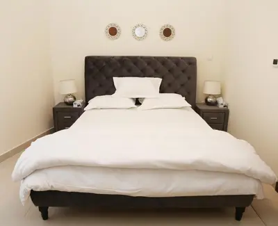 a bedroom with a large white bed with two night stands at Luxury Two Bedroom Apt Facing Burj Khalifa in Dubai