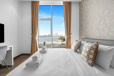 a bedroom with a white bed with a view of the ocean at Burj Alarab & Atlantis Palm Sea view, Beachfront, peaceful 3 Bedroom Apartment TIARA Residence with Pool, fast Wifi in Dubai