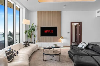 a living room with a couch and a tv at Burj Alarab & Atlantis Palm Sea view, Beachfront, peaceful 3 Bedroom Apartment TIARA Residence with Pool, fast Wifi in Dubai