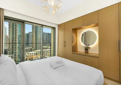 a bedroom with a white bed and a large window at Burj Royale 1 BR 5 Min Walk to Burj Khalifa in Dubai