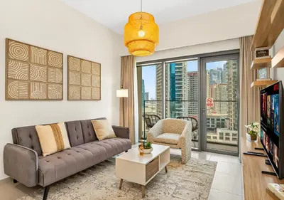 a living room with a couch and a tv at Burj Royale 1 BR 5 Min Walk to Burj Khalifa in Dubai