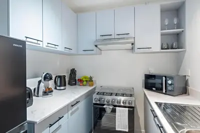 a white kitchen with a stove and a microwave at Stylish Dubai Downtown Studio by Burj Khalifa in Dubai
