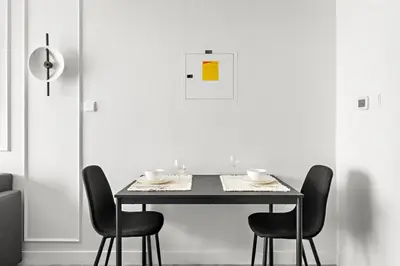 a dining room table with black chairs and a yellow sign at Stylish Dubai Downtown Studio by Burj Khalifa in Dubai