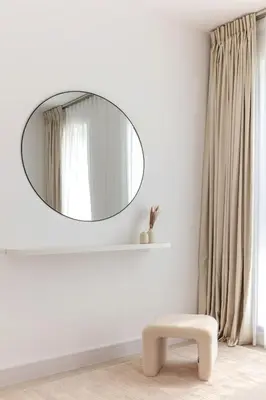 a round mirror in a white room with a stool at Luxury One-Bedroom Burj Khalifa in Dubai