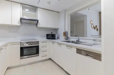a white kitchen with a sink and a microwave at Luxury One-Bedroom Burj Khalifa in Dubai