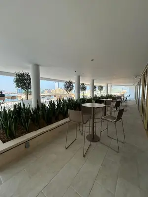 a cafeteria with tables and chairs in a building at Sea-facing 1BR at Beachfront 50 Off Eid Promo in Dubai