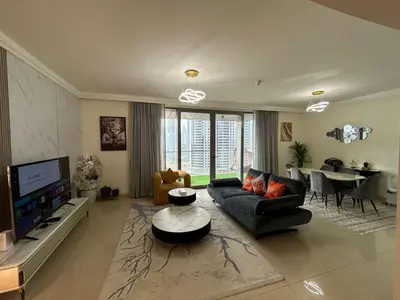 a large living room with a couch and a tv at 2BR Full Burj Khalifa View - Eid Promo 50 Off in Dubai