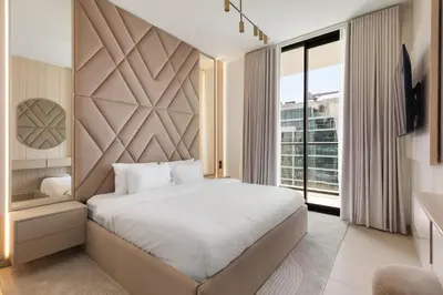 a bedroom with a large bed and a large window at Your Own Pool Spacious 2BDR Apartment JVC in Dubai